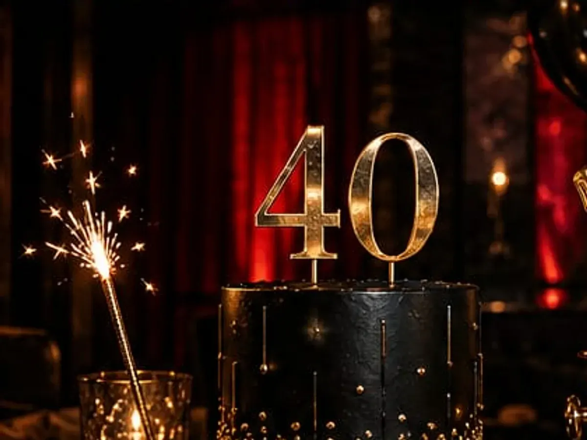 Mesa de aniversário na MD Cult Club: bolo com topo "40", champanhe no balde e balões dourados